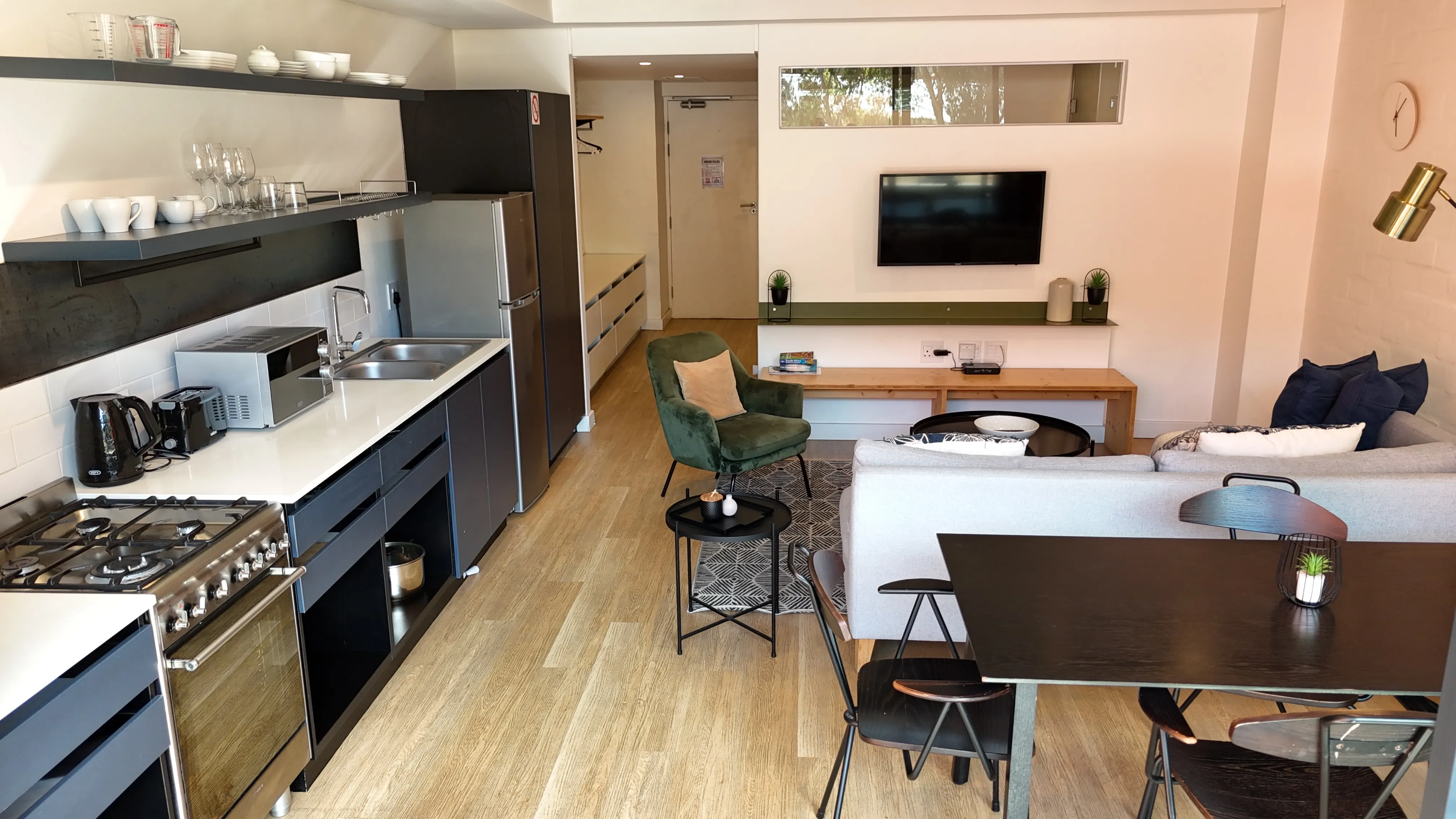 Área de estar e refeições com sofá, TV e mesa de jantar